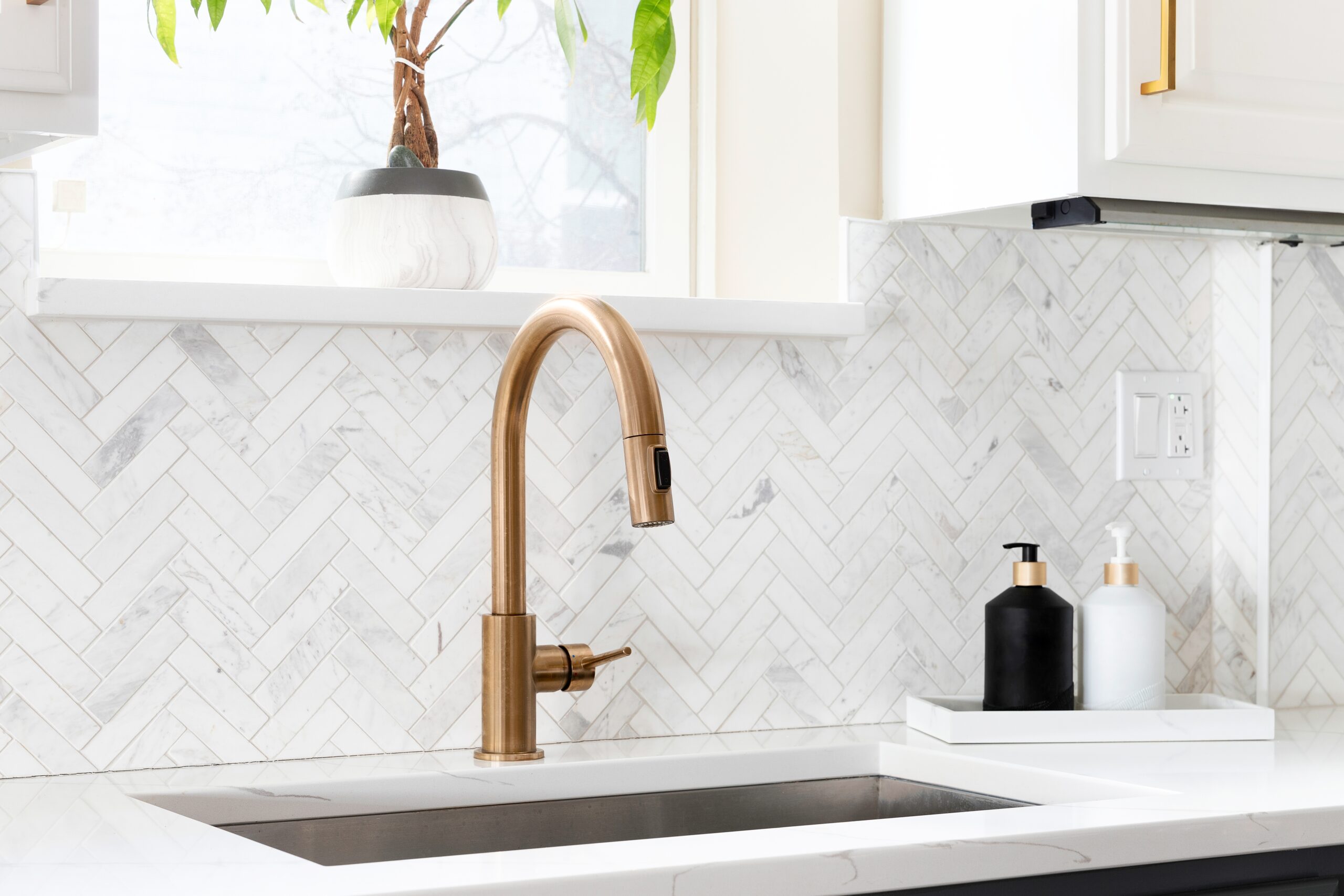 Sink,detail,shot,in,a,luxury,kitchen,with,herringbone,backsplash