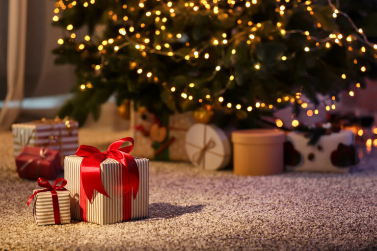 Beautiful,christmas,gift,boxes,on,floor,near,fir,tree,in
